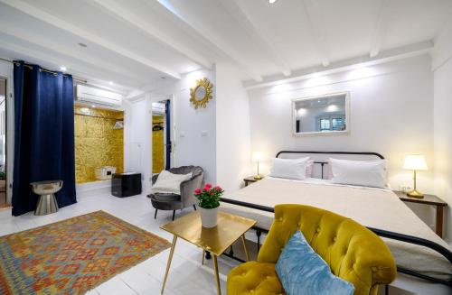 a bedroom with a large bed and a yellow chair at Swan Adriatic Apartment & Room in Šibenik