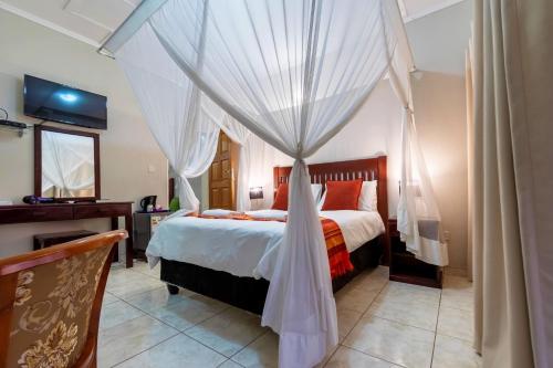 a bedroom with a bed with a canopy at Dzimbahwe Guest Lodge in Victoria Falls