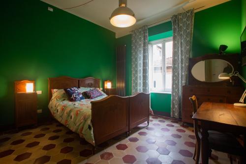 um quarto verde com uma cama e um espelho em La Terrazza Del Fotografo em Lucca