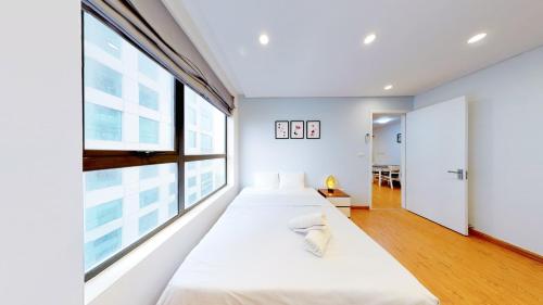 two beds in a room with a large window at HongKong Tower managed by Lily Home in Hanoi