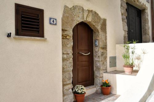 a door of a building with two potted plants at La Domus di Segesta in Calatafimi