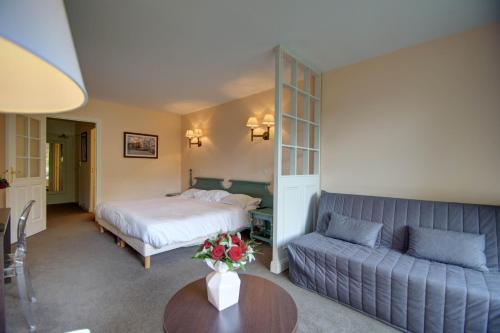 a hotel room with a bed and a couch at Hôtel du Parc in Hardelot-Plage
