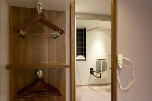 a wooden door with a shower in a bathroom at Holiday Inn Express Dunstable by IHG in Dunstable
