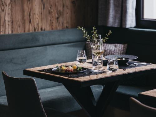 a table with a plate of fruit and wine glasses at VAYA Zillertal inklusive Gästekarte Erste Ferienregion Zillertal in Aschau