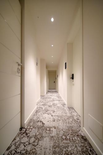 an empty hallway with white walls and marble floors at Bergamo Inn 15 in Bergamo
