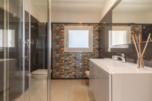 ein Bad mit einem Waschbecken, einer Dusche und einem WC in der Unterkunft Residence Meridian Unità 4 in Villa San Pietro