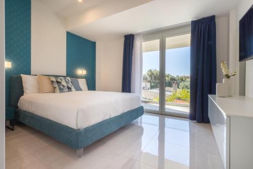 ein Schlafzimmer mit einem Bett und einem großen Fenster in der Unterkunft Residence Meridian Unità 4 in Villa San Pietro