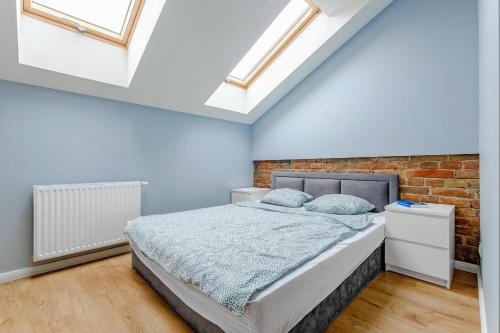 ルブリンにあるApartament w centrum, zarezerwuj terazのベッドとレンガの壁がある寝室