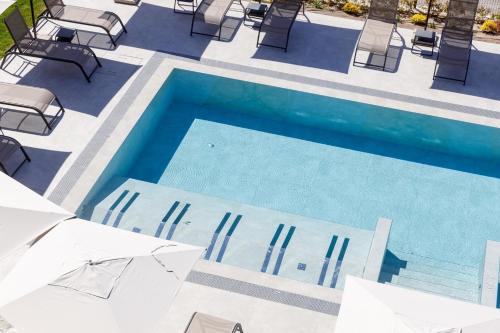 an overhead view of a swimming pool with chairs and umbrellas at Deville & Spa in Costermano sul Garda