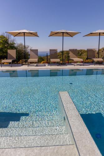 a swimming pool with chairs and umbrellas at Deville & Spa in Costermano sul Garda