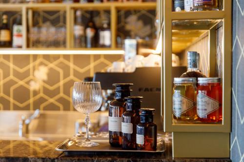 a counter with bottles of alcohol and a wine glass at Deville & Spa in Costermano sul Garda