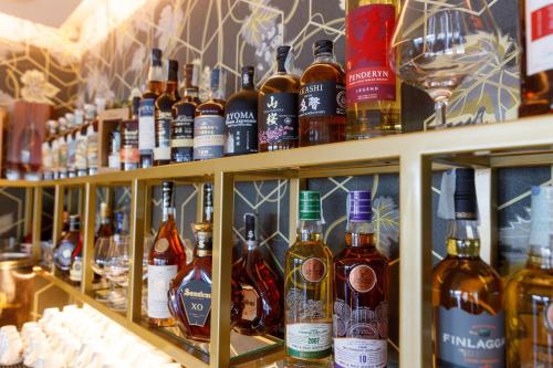 a shelf filled with lots of bottles of alcohol at Deville & Spa in Costermano sul Garda