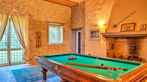 a pool table in a room with a fireplace at Casale Cicognola 12, Emma Villas in Massa Martana