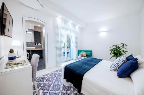 a white bedroom with a bed and a desk at Villa Livia in Ischia