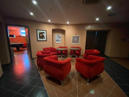 a waiting room with red chairs and a table at Boutique Hotel Sopianae in Pécs