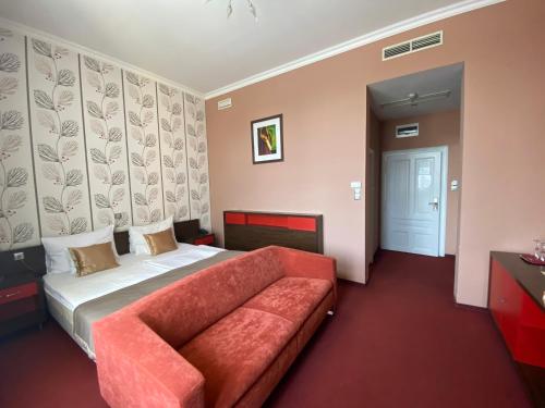 a hotel room with a bed and a couch at Boutique Hotel Sopianae in Pécs
