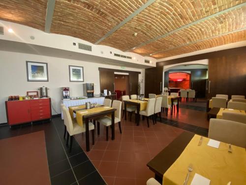 a dining room with tables and chairs in a restaurant at Boutique Hotel Sopianae in Pécs