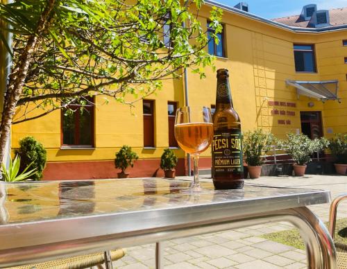 a bottle of beer and a glass of wine on a table at Boutique Hotel Sopianae in Pécs