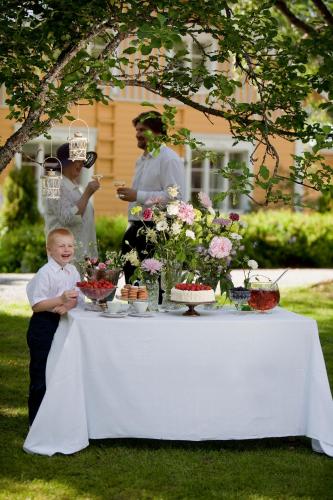 a little boy standing next to a table with food at Taulun Kartano in Kankainen