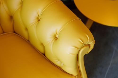 a close up of a yellow leather couch at Deville & Spa in Costermano sul Garda