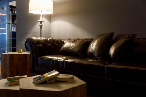 a brown leather couch in a living room with a table at Deville & Spa in Costermano sul Garda