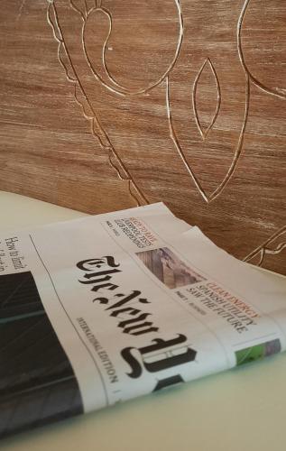 a newspaper sitting on top of a wooden table at Olympic Fashion Hotels in Athens