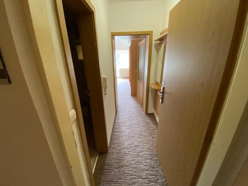 an empty hallway with a hallway leading into a room at The Legits Apartments in Donovaly