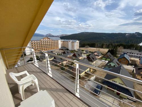 a balcony with a chair and a view of a city at The Legits Apartments in Donovaly