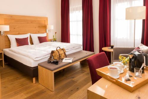 a hotel room with a bed and a table at Landgasthof Euler in Neuschönau