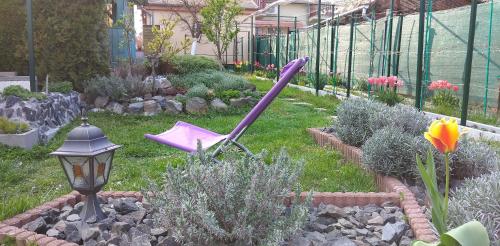 a garden with a purple umbrella laying in the grass at Maxim Ház in Hévíz