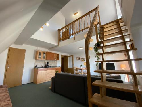 a living room with a staircase and a kitchen at The Legits Apartments in Donovaly