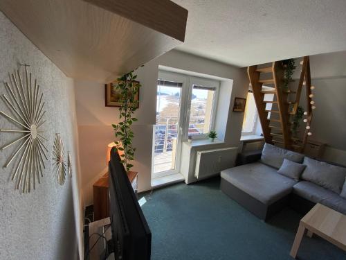 a living room with a couch and a stair case at The Legits Apartments in Donovaly