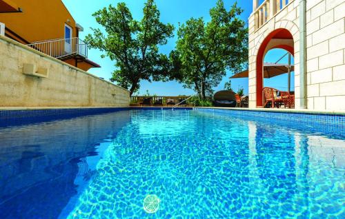 uma piscina com água azul em frente a um edifício em Villa Anka em Zaton