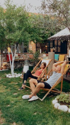 two women and a man sitting in lawn chairs at Attalos Suites Hotel in Bergama
