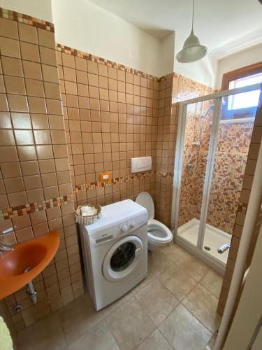 a bathroom with a washing machine and a toilet at Il Pepe Rosa - Valle D'Itria in Martina Franca