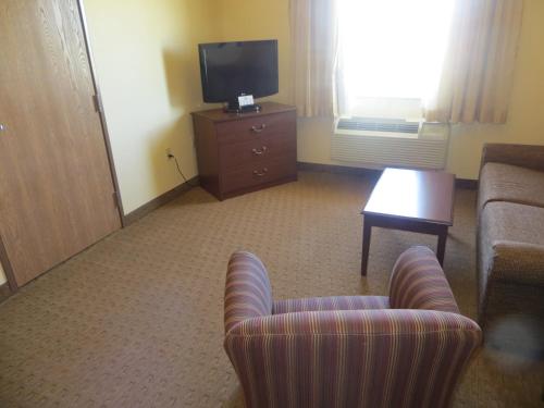 a living room with a couch and a tv at Days Inn by Wyndham Ellis in Ellis