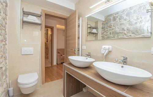 a bathroom with a sink and a toilet and a mirror at Heritage Residence in Center with pool in Vodice