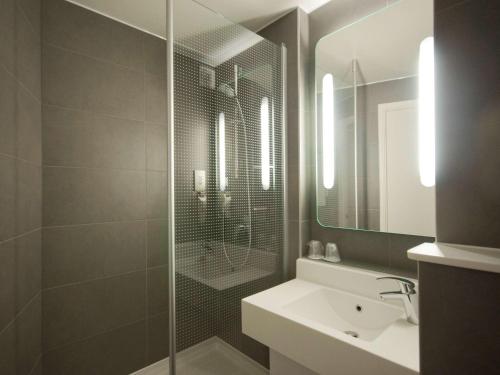 a bathroom with a shower and a sink and a mirror at ibis London Thurrock M25 in Grays Thurrock