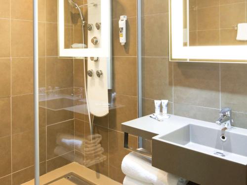 a bathroom with a sink and a shower at Mercure Béziers in Béziers