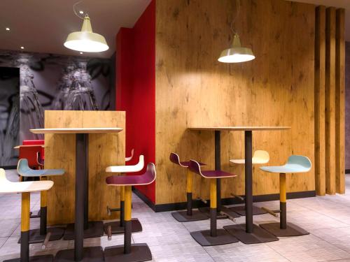a room with two tables and colorful chairs at Ibis Bilbao Centro in Bilbao