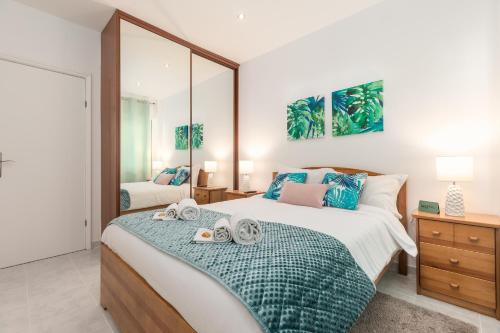 1 dormitorio con 1 cama con 2 toallas en Aquazul Beach Flat - Praia da Rocha en Portimão