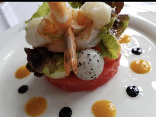 a plate of food with shrimp on top of a tomato at Paolos Seehotel Mardorf in Mardorf
