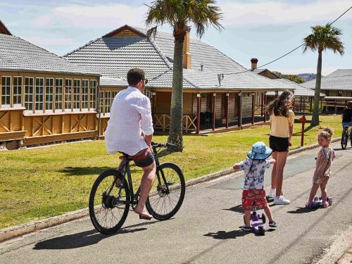 a man riding a bike and a child on roller skates at Q Station in Sydney