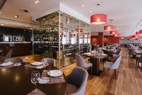 a restaurant with tables and chairs and a wine cellar at Hotel Premium Chaves - Aquae Flaviae in Chaves