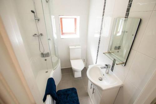 a white bathroom with a sink and a toilet at Derry City Private Apartment in Culmore