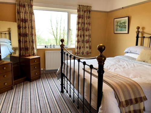 a bedroom with a large bed and a window at Cottage on the Hill in Penrith
