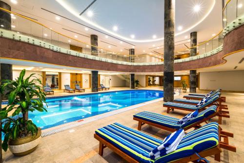 a swimming pool with lounge chairs in a building at Boudl Al Munsiyah in Riyadh