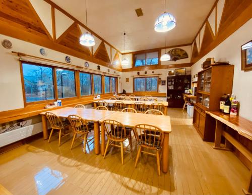 a large dining room with wooden tables and chairs at ROSSI STAR in Hakuba