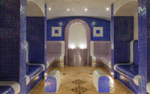 a room with blue tiled walls and benches at Royal Spa Hotel in Velingrad