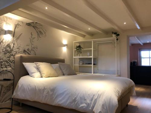 a bedroom with a large bed with white sheets at Stadsdromer in Middelburg